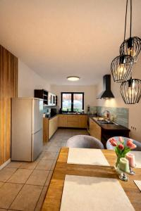 a kitchen with a stainless steel refrigerator and a table at Ferienhaus ,,Pier 7" am See - 2 Wohnungen mit Garten für bis zu 11 Personen, einzeln oder zusammen buchbar in Große Mühle