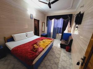 a bedroom with a large bed with a red blanket at Pratap Resort in Katra