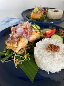 a blue plate of food with rice and vegetables at Adisamasta Guesthouse in Sidemen