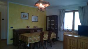 a dining room with a table and a desk and a window at Appartamento Elena in Bormio