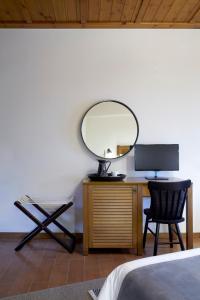 a bedroom with a desk with a mirror and a chair at Levanta in Méga Khoríon