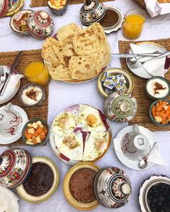 a table filled with plates and bowls of food at Riad Lia ou Lik in Marrakesh