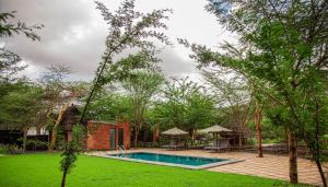 a backyard with a swimming pool and trees at Kutoka Lodge in Arusha