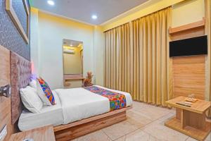 a hotel room with a bed and a television at hotel hill top inn vatva in Ahmedabad