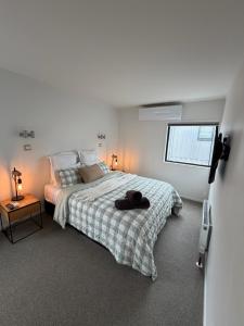 a white bedroom with a bed and a window at T Two on Whakaue in Rotorua