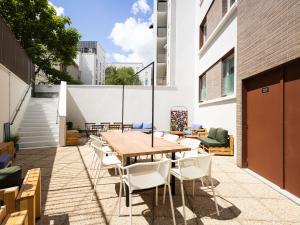 an outdoor patio with a wooden table and chairs at ibis budget Nanterre la Defense in Nanterre