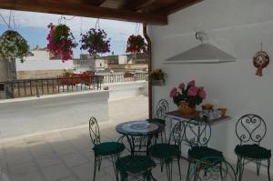 een patio met een tafel en stoelen en een balkon bij Casa Camilla in Massafra