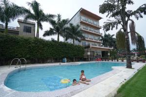two children are playing in a swimming pool at Paradise Resort Paonta in Pāonta Sāhib
