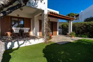 a patio with a table and chairs in a yard at Villa Rania - Porto Hydra in Ermioni