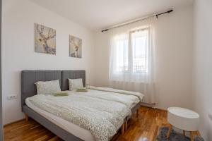 a bedroom with a large bed and a window at HM Apartments in Inđija