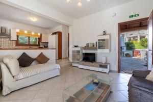 a living room with a couch and a glass table at Villa Rania - Porto Hydra in Ermioni +25 photos