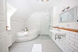 ein weißes Badezimmer mit einer Badewanne und einem Waschbecken in der Unterkunft Hotel Højslev Kro in Højslev