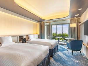 a hotel room with two beds and a window at Kiyosato Kogen Resort in Hokuto