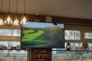 a flat screen tv hanging in a room with windows at Hotel Allee 55 in Hannover