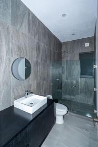 a bathroom with a sink and a toilet and a shower at Arch View Luxury Condo with Heated Rooftop Pool and Jacuzzi in Cabo San Lucas +30 photos