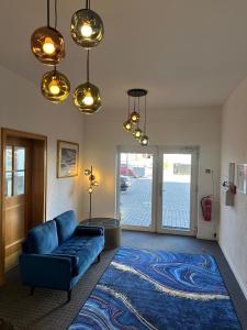a living room with a blue couch and a blue rug at Hotel Torgauer Brauhof in Torgau