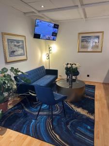 a living room with a couch and a tv on the wall at Hotel Torgauer Brauhof in Torgau