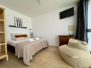 a bedroom with a bed and a chair at Studio le Capricorne 22 in Martigny-Ville