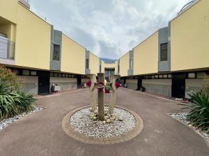 a building with two trees in the middle of a road at Studio le Capricorne 22 in Martigny-Ville