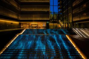 a large swimming pool with blue lights in a building at THE THOUSAND KYOTO in Kyoto