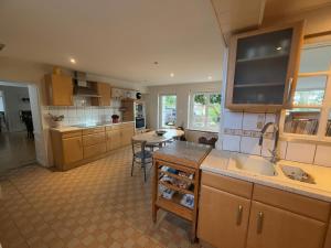 a large kitchen with a sink and a table at Demeure Saint Gildas in La Haye-Pesnel +2 photos