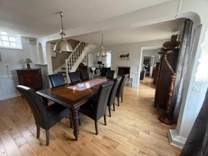 a dining room with a wooden table and black chairs at Demeure Saint Gildas in La Haye-Pesnel