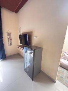 a room with a refrigerator and a tv in it at Villa Bianca Lovina by GEMA MANAGEMENT BALI in Lovina