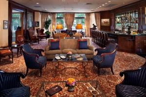 a living room with a couch and chairs and a bar at The Windsor Court in New Orleans