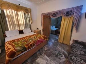 a bedroom with a bed with a giraffe bedspread at Pratap Resort in Katra