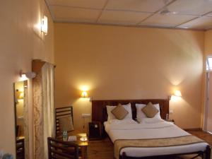 Hāflong的住宿－Landmark Hotels,Haflong，卧室配有一张带白色床单和枕头的大床。
