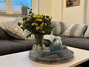 a vase of flowers on a table in a living room at TauberGenuss in Werbach