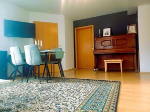 a living room with a table and chairs and a piano at TauberGenuss in Werbach