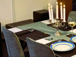a dining room table with candles and plates and chairs at TauberGenuss in Werbach