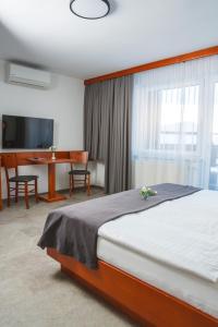 a bedroom with a bed and a dining room with a table at Hotel Tripič, restaurant and pizzeria in Bohinj