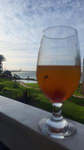 a glass of beer sitting on a ledge with a view of the ocean at 130 Brookes Hill Suites in Port Elizabeth +15 photos