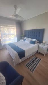 a bedroom with a large bed with a blue headboard at 130 Brookes Hill Suites in Port Elizabeth