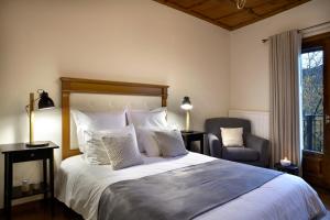 a bedroom with a large bed and a chair at Levanta in Megalo Chorio