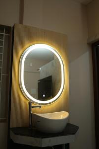 a bathroom with a large white sink and a mirror at RUBY Residency in Palni +3 photos