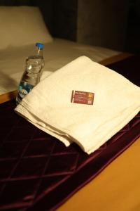 a bottle of water next to a napkin and a bottle of water at RUBY Residency in Palni