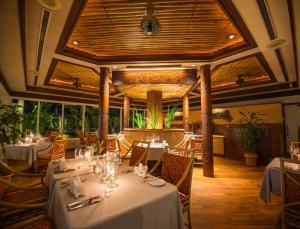 科罗尔Palau Pacific Resort & The Pristine Villas and Bungalows的摆放着白色桌椅的餐厅