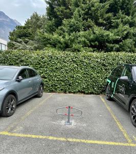 two cars are parked in a parking lot at Studio le Capricorne 22 in Martigny-Ville +4 photos