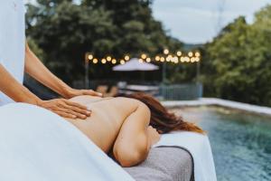a woman getting a massage from a massage therapist at Respiro Umbria, 1500s Villa with Unique Biopool in Spoleto