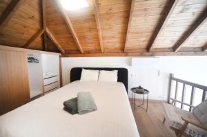a bedroom with a large white bed with wooden ceilings at Anoi Kalymnos in Khoríon