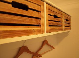 a wooden cabinet in a room with a shelf at Strandhaus Heiligenhafen in Heiligenhafen