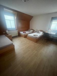 a large room with two beds and two windows at Sandstein- & Maerchenhoehle Walldorf GbR in Walldorf