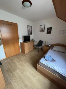 a bedroom with a bed and a desk with a television at Sandstein- & Maerchenhoehle Walldorf GbR in Walldorf
