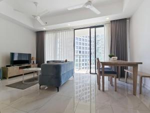 a living room with a blue chair and a table at Evolve - Céleste in Colombo