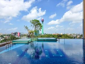 a swimming pool with a water tower in the background at Evolve - Céleste in Colombo