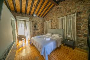 a bedroom with a bed and a brick wall at Farmakas Living in Pharmakas
