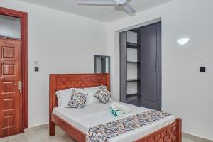a bedroom with a bed with a wooden headboard at Diani Tulivu in Diani Beach +50 photos